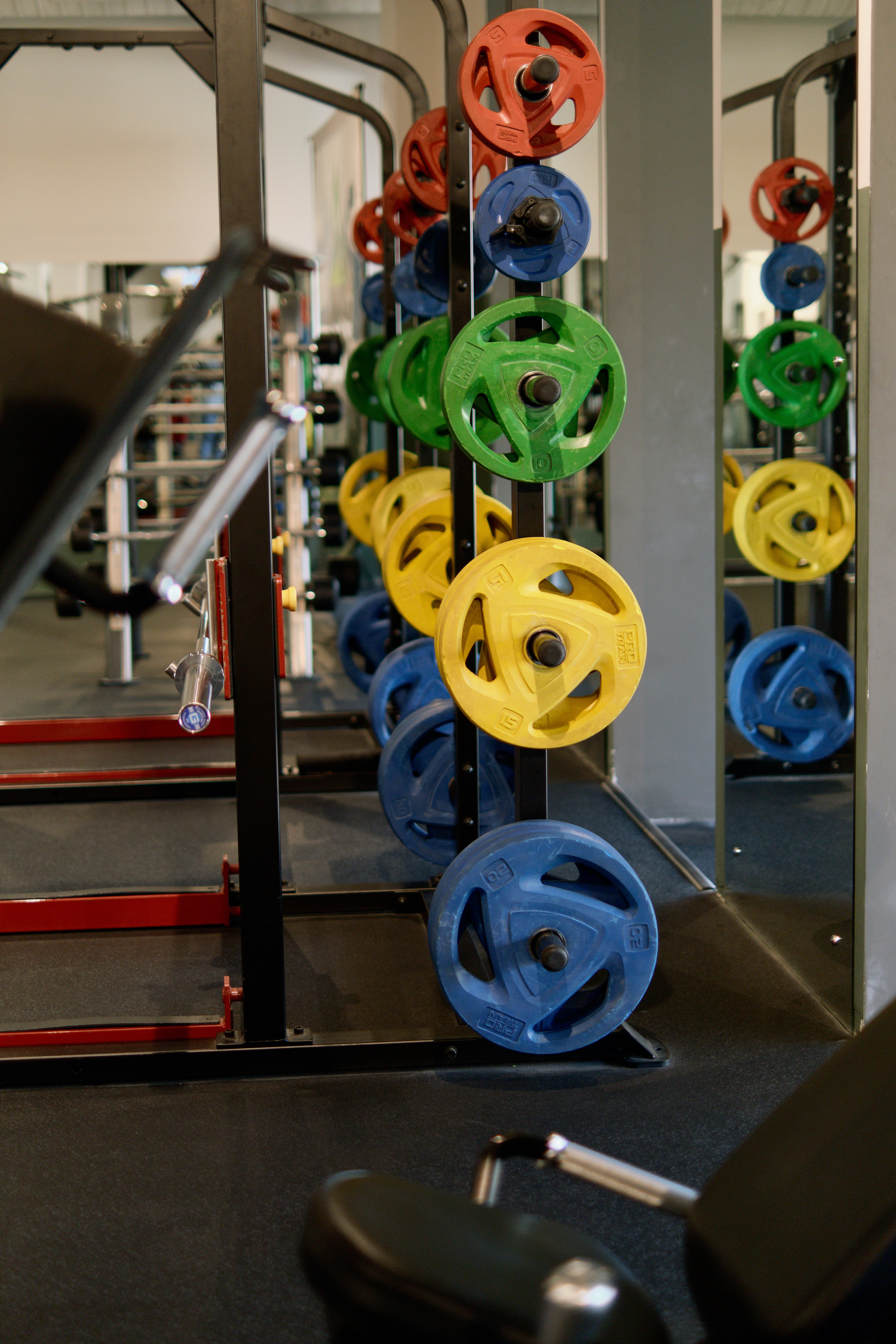 a squat rack with weights of different colours